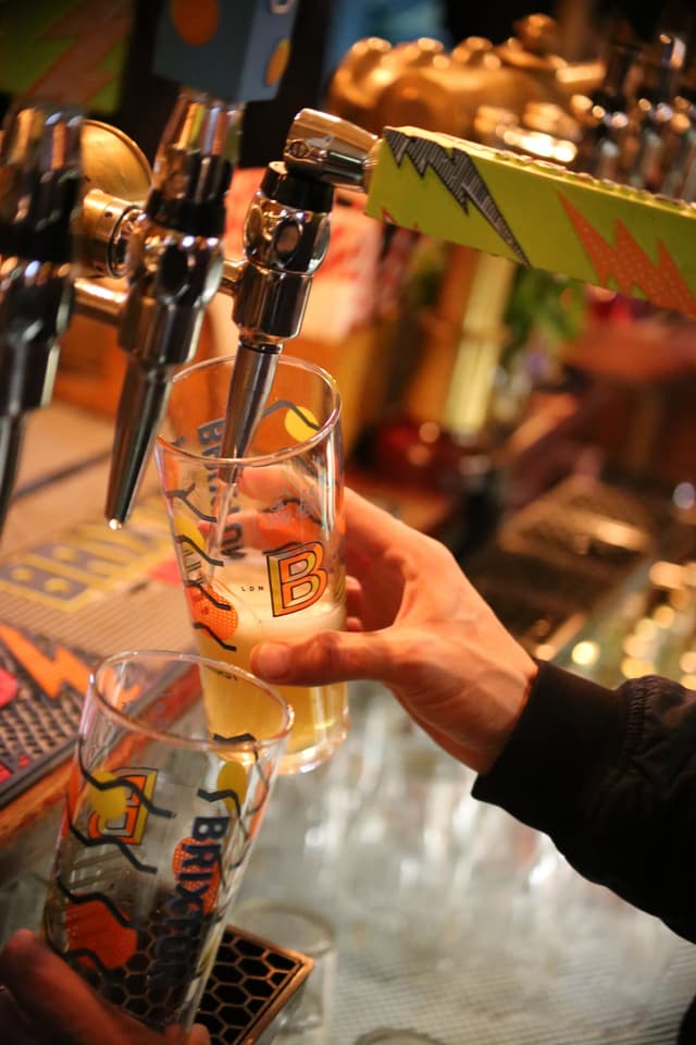 Bartender pouring one pint while holding the next